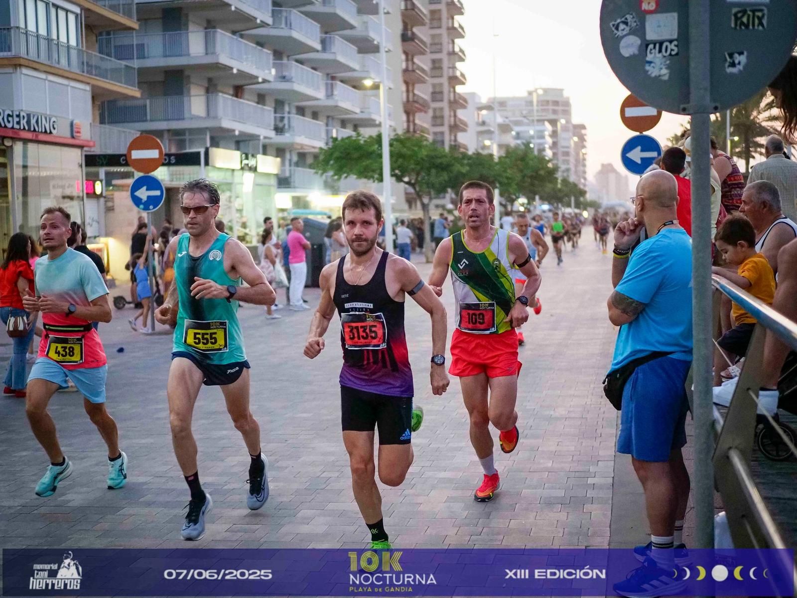 Corredores por el paseo marítimo de la Playa de Gandia al atardecer